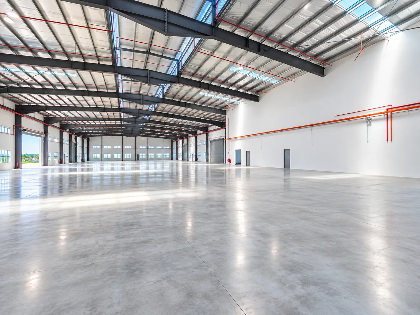Detached factory for sale in Desa Cemerlang – interior with roller shutter doors