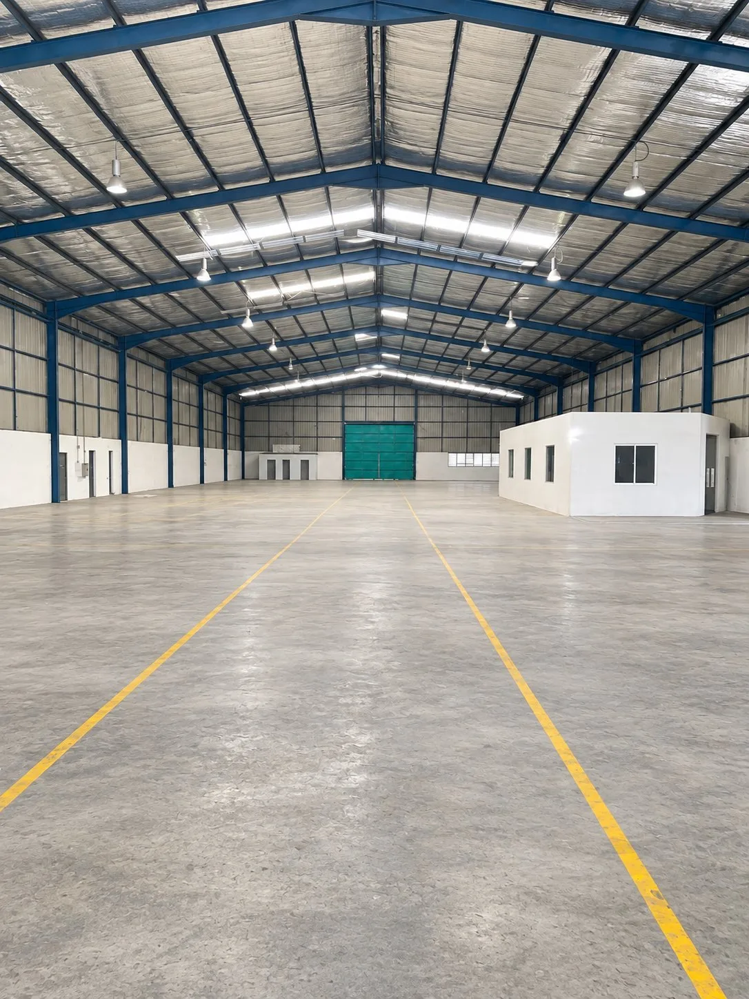 Seelong factory for rent – production floor Open production floor with a steel roof, skylights and a small office inside the detached factory for rent in Seelong, Senai
